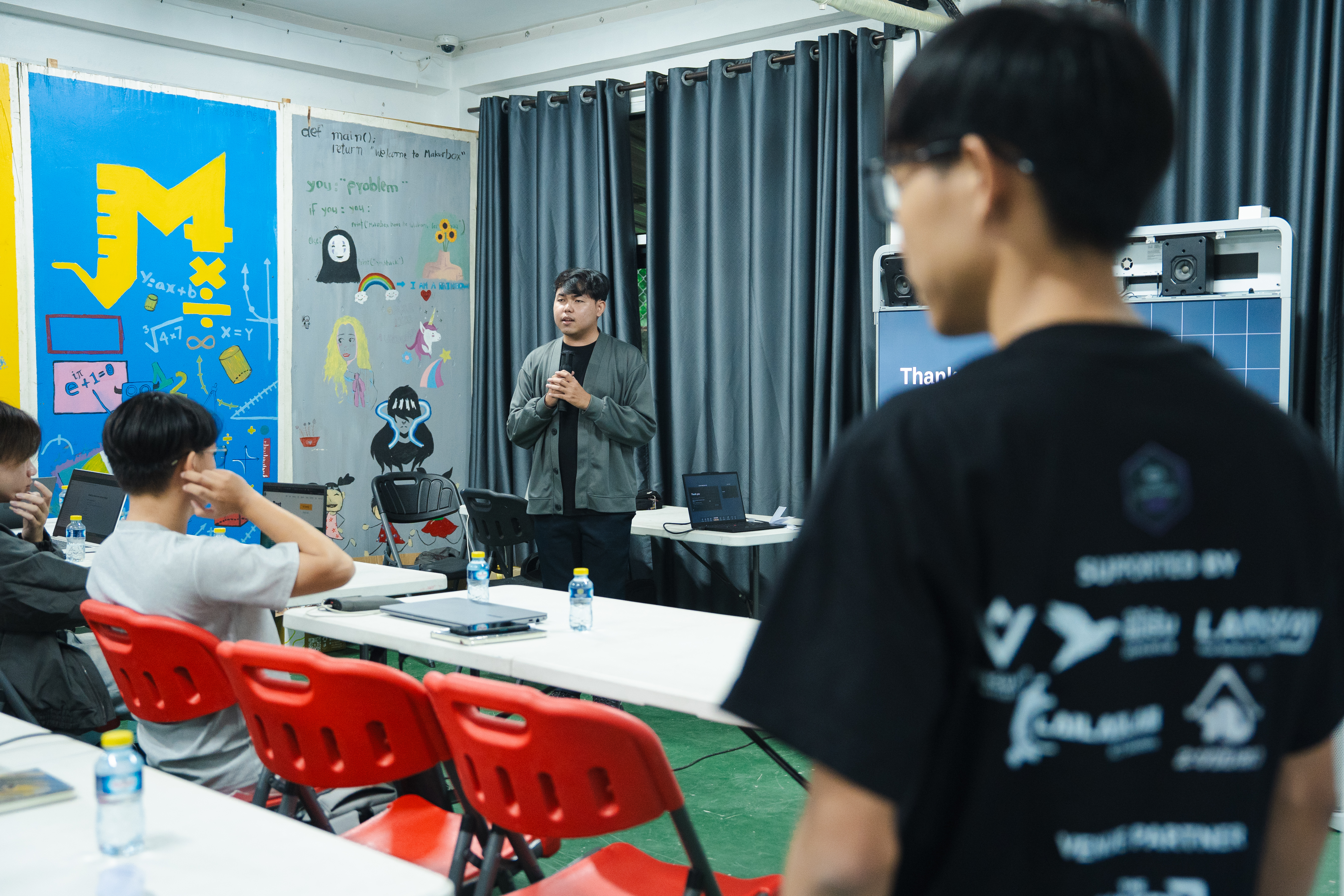 Wide view of the meetup room, with an attendee in an AWS User Group Lao shirt in the foreground